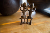 Vintage African bronze figures' lower bodies and legs, highlighting handmade texture and aged patina.