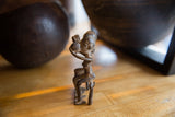 Detail of vintage African bronze sculpture, highlighting textured lower body and aged patina.