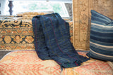 Vintage African indigo throw, folded, with hand-woven texture and pink, yellow, blue dashed lines.