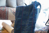 Collectible hand-woven African indigo throw, showing textured weave with blue, pink, yellow stripes.