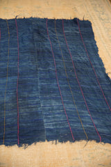 Hand-woven African indigo textile featuring variegated texture and colorful stitched lines.