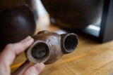 A close-up view of the two aged openings in the hand-carved African ceremonial wine cup.