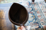 A view into the dark, aged interior of the handmade wooden pitcher.