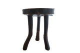 Dark handmade vintage African wooden stool with tripod legs and visible natural wear.
