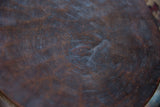Textured dark brown wooden surface of the vintage African stool with scratches and patina.