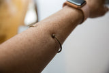 Vintage African thin bronze cuff bracelet showing its simple fit on a forearm.