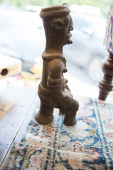 Lower section of the antique African terracotta figure, showing handmade texture.
