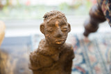 Textured terracotta face and separated head of the antique African Nkisi figure.