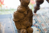 Rough, textured terracotta surface of the antique African fetish figure's upper body.