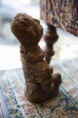 Textured side view of an antique African Nkisi fetish figure, emphasizing its raw charm.