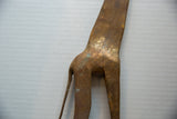 Aged patina and hand-etched textural patterns on a vintage African bronze giraffe's body.
