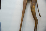 Aged bronze alloy texture on the slender hind legs and tail of the vintage giraffe.