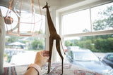 A hand holding the vintage bronze alloy giraffe to demonstrate its balance and stability.