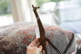 Vintage African bronze giraffe held in hand, showing the collectible's scale and texture.