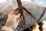 Textured surface and paper inventory tag on a vintage bronze giraffe.