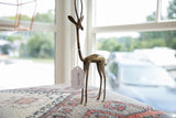 Elegant profile and handmade surface details of a vintage African bronze gazelle.