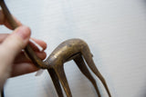 Aged bronze patina and handmade surface texture on the vintage gazelle's curved back.
