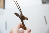 The hand-cast texture and simple form of the vintage African bronze gazelle's head.