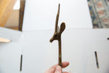Aged bronze gazelle sculpture head, showing textured horn, ear, and green patina.