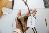 Vintage African bronze alloy gazelle with aged texture, highlighted by a white SKU tag.