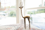 The elegant, long-legged form of a vintage bronze gazelle with a warm patina.