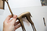 Aged bronze patina on the smooth, curved back of a handmade vintage gazelle sculpture.