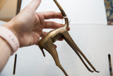 The handmade texture and aged patina on the body of the bronze gazelle.