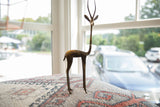 The stylized, slender form of a vintage handmade African bronze gazelle sculpture.