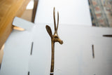 Side profile of the vintage bronze gazelle's head showing its long, textured horns.