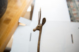 The head and slender, textured horns of a vintage bronze gazelle sculpture.