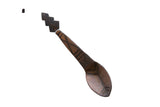 Vintage African wooden spoon with a carved instrument-shaped handle and etched geometric patterns.