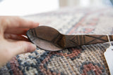 Hand-carved geometric details on the dark, textured wood of a vintage African spoon.