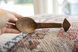 Aged patina and carved details on a vintage handmade African wooden spoon.