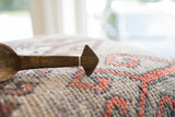 The vintage wooden spoon's hand-carved handle with a geometric point.