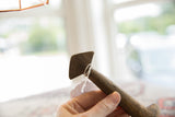 The unique angular head and aged, dark wood grain of a vintage African spoon.