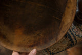 Hand-stitched repairs and aged patina on the interior of a vintage African wooden bowl.