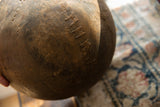 Detailed view of the aged patina and storied repairs on a vintage African bowl.