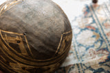 Detailed carved patterns and visible historic repairs on a vintage African wooden bowl.
