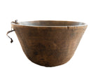 Vintage African wooden bowl with a warm patina, incised patterns, and visible repairs.