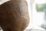 Zigzag metal repair along the etched geometric patterns of a vintage wooden bowl.