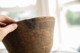 Historic repair and etched geometric details on the vintage wooden bowl's side.