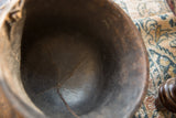 Close-up of the dark, textured interior of the vintage African bowl, showing age cracks.