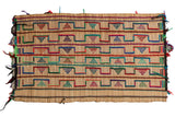 Vintage African Tuareg mat woven from straw with colorful geometric patterns.
