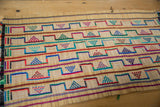 Handwoven texture and colorful geometric threadwork on a vintage African Tuareg straw mat.