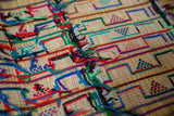 Detail of handwoven straw and colorful shaggy yarn on a vintage African Tuareg mat.