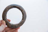 The hand-carved texture of an antique marble bracelet shown in hand for scale.