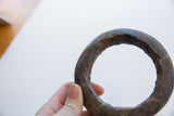 Angled view of a Neolithic era marble bracelet highlighting its rugged, hand-carved texture.