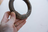 Antique marble bracelet held in hand to show its substantial scale and rustic texture.