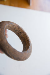 Hand-carved texture and time-worn patina on a Neolithic marble bracelet.