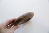 Holding the antique African marble bracelet to show its scale and hand-carved texture.